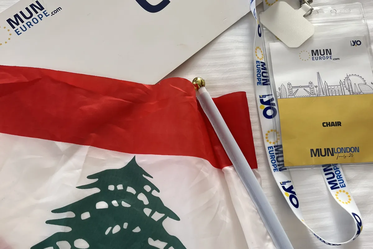 A national flag, a chair placard and a mymun lanyard on a committee desk